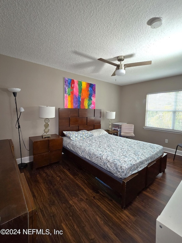 bedroom featuring dark wood-type flooring, a textured ceiling, and ceiling fan