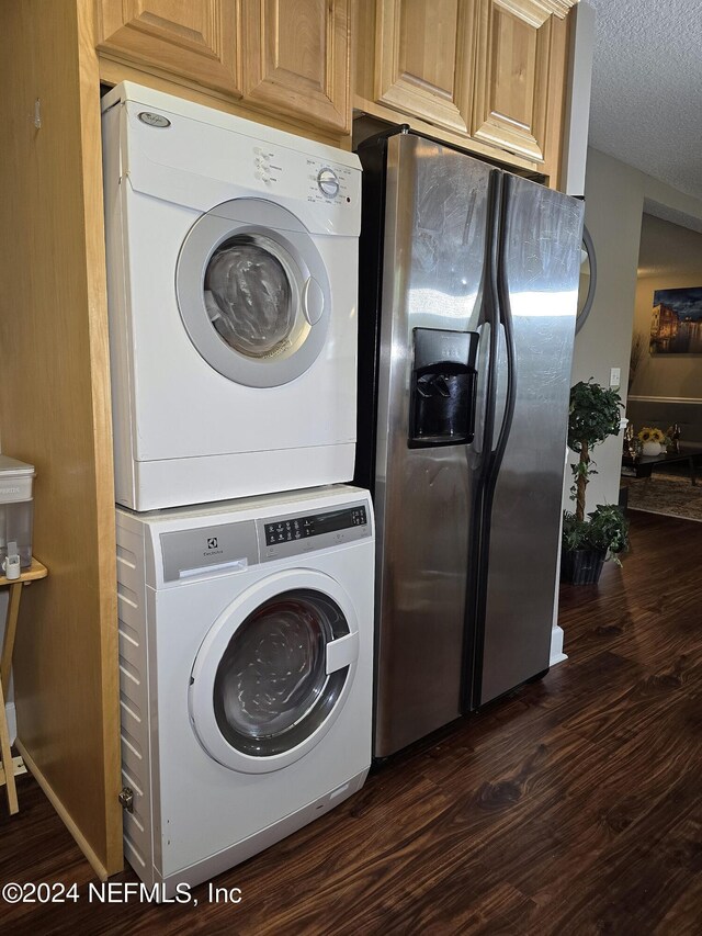 washroom featuring dark wood-type flooring, stacked washer and dryer, and a textured ceiling