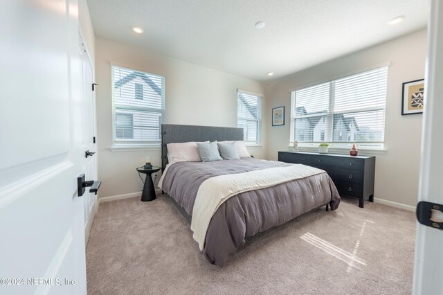 carpeted bedroom featuring multiple windows