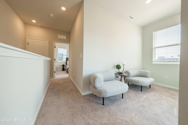 sitting room featuring light carpet