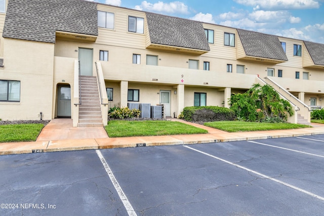 8550 A1A Unit 241, Saint Augustine, FL 32080 - view of building exterior featuring stairway, uncovered parking, and central air condition unit