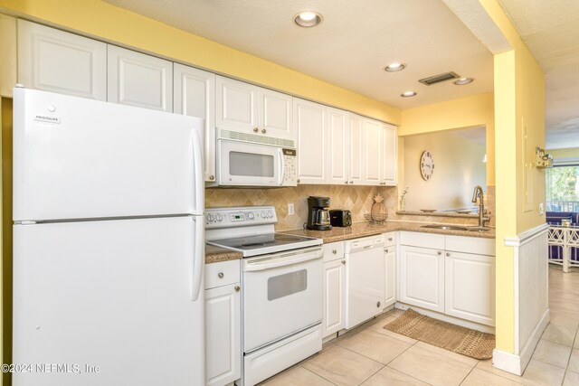 kitchen with white appliances, light tile patterned floors, sink, decorative backsplash, and white cabinets