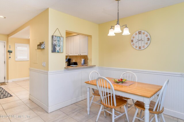 tiled dining area featuring an inviting chandelier