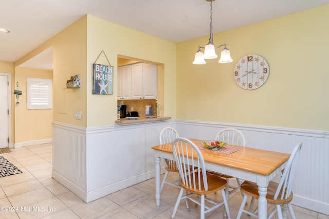 8550 A1A Unit 241, Saint Augustine, FL 32080 - dining area with light tile patterned floors, a notable chandelier, and wainscoting