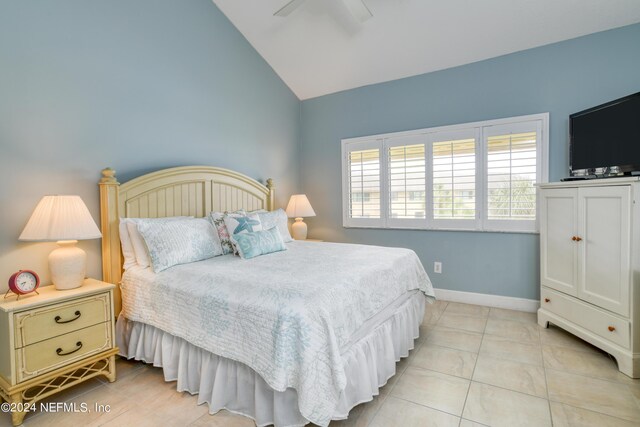 bedroom with lofted ceiling, ceiling fan, and light tile patterned floors