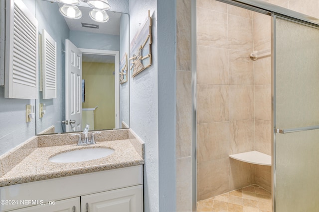 bathroom with vanity, walk in shower, and tile patterned flooring