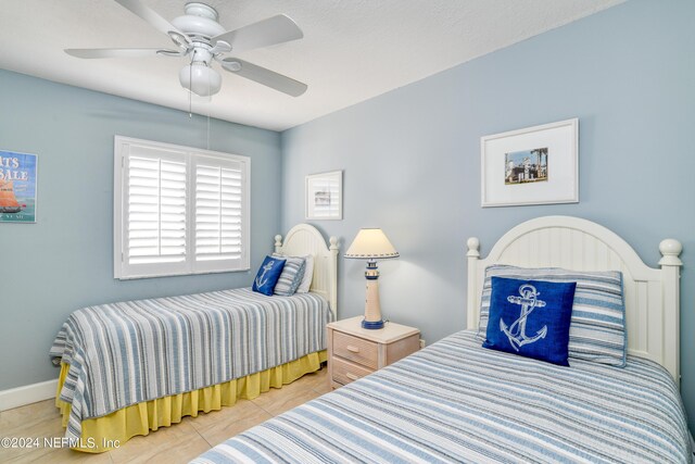 tiled bedroom featuring ceiling fan