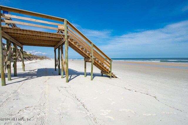 view of home's community with a water view and a view of the beach