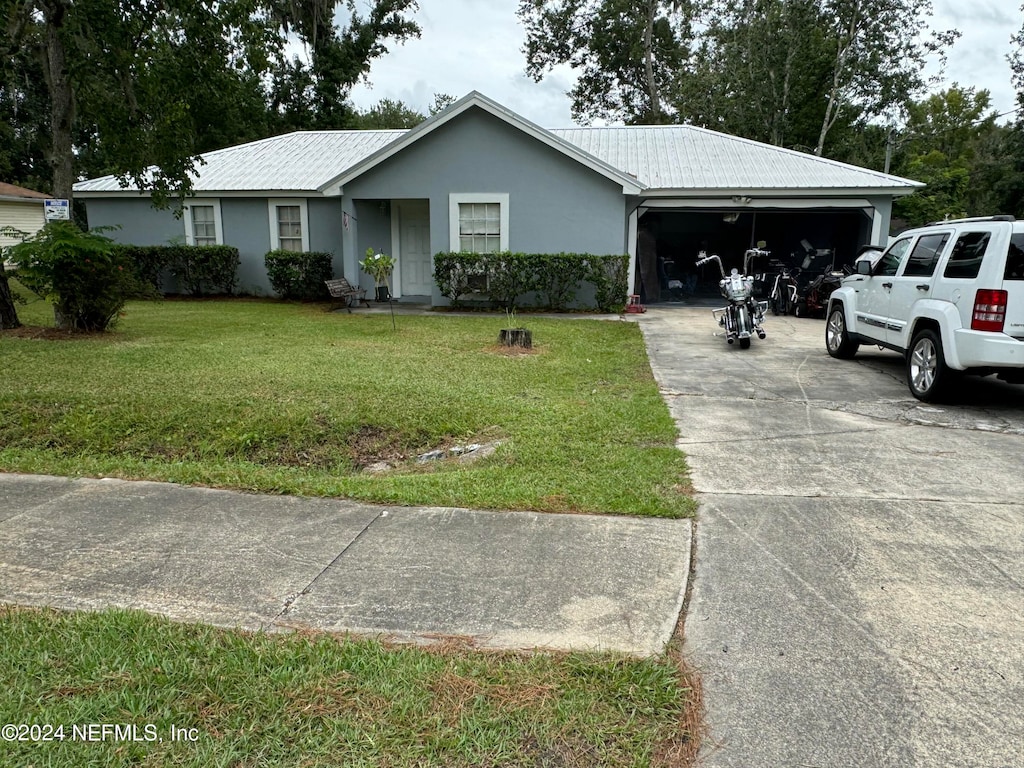 ranch-style house with a garage and a front lawn