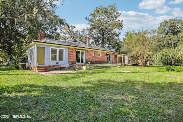 rear view of house featuring a lawn