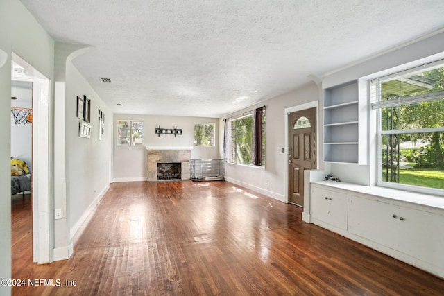 unfurnished living room with a high end fireplace, a textured ceiling, and dark hardwood / wood-style flooring