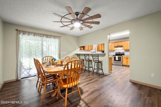 dining space with a textured ceiling, wood-type flooring, and ceiling fan