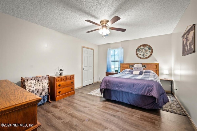 bedroom featuring light wood-type flooring, a textured ceiling, and ceiling fan