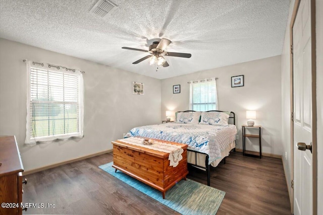 bedroom with ceiling fan, dark hardwood / wood-style floors, and multiple windows