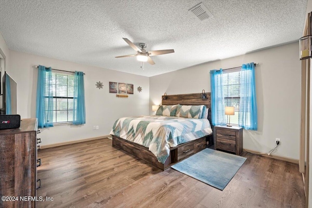 bedroom featuring a textured ceiling, hardwood / wood-style floors, and ceiling fan