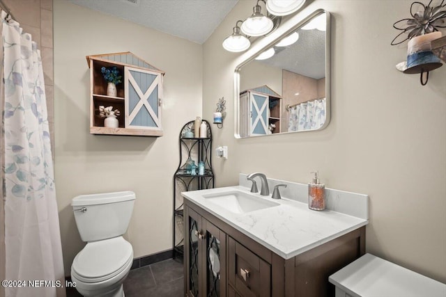 bathroom with a textured ceiling, vanity, toilet, and tile patterned floors