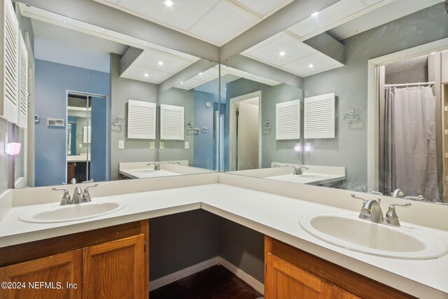 bathroom with hardwood / wood-style floors, walk in shower, and vanity