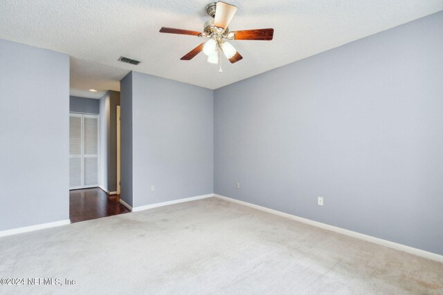 carpeted empty room featuring a textured ceiling and ceiling fan