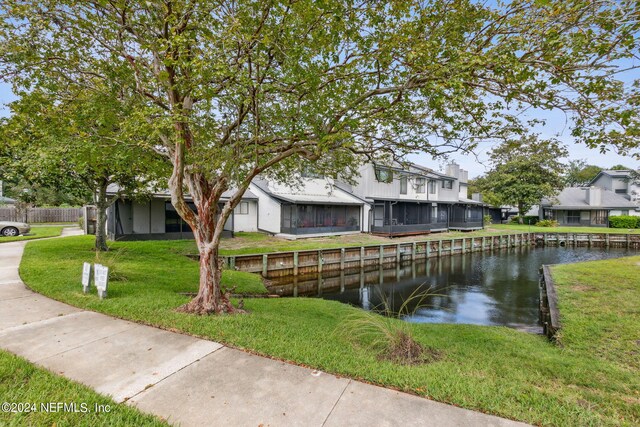 exterior space with a water view and a front lawn