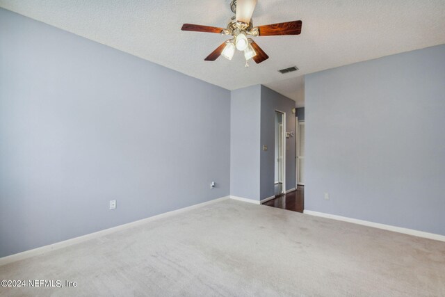 carpeted spare room featuring a textured ceiling and ceiling fan