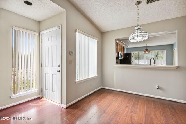 foyer with a textured ceiling, wood-type flooring, and sink