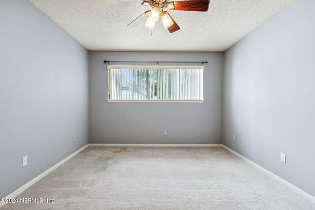 empty room with a textured ceiling, carpet, and ceiling fan