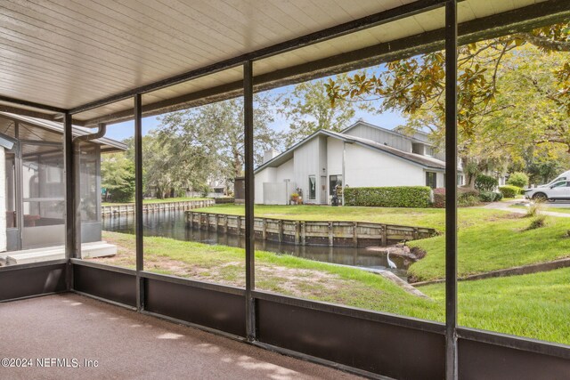 unfurnished sunroom with a water view