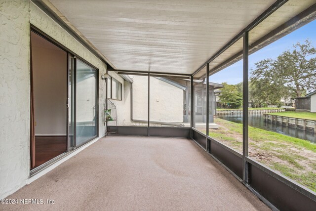 unfurnished sunroom featuring a wealth of natural light and a water view