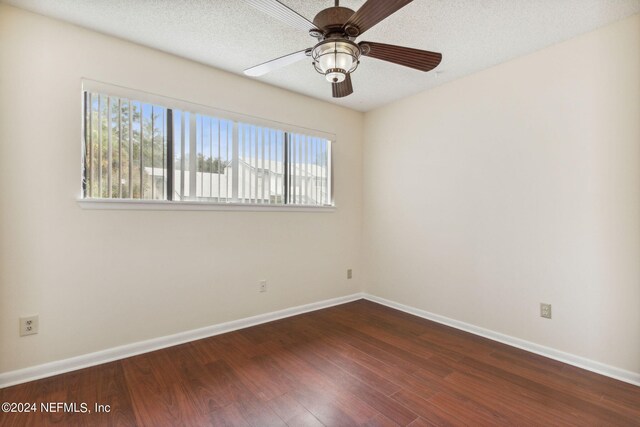 spare room featuring dark hardwood / wood-style flooring, plenty of natural light, ceiling fan, and a textured ceiling