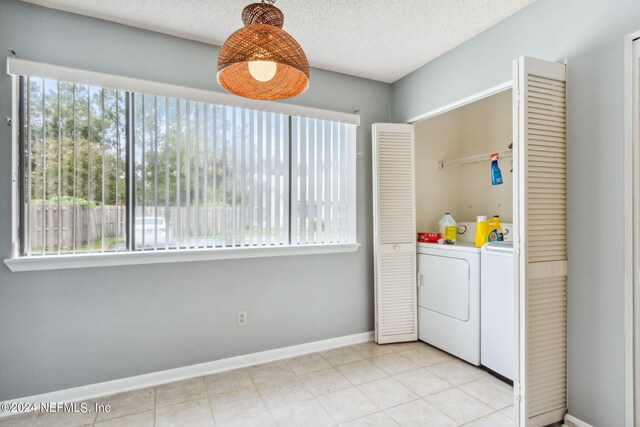 laundry area with washer and clothes dryer and a textured ceiling