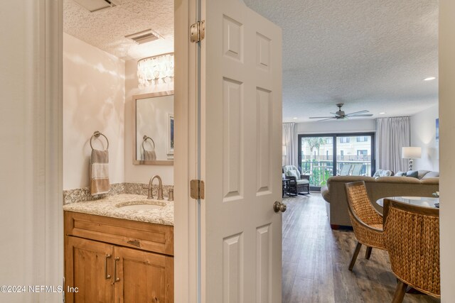 bathroom featuring a textured ceiling, vanity, ceiling fan, and hardwood / wood-style flooring