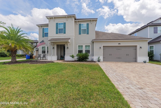 view of front of property with a front lawn, decorative driveway, and an attached garage