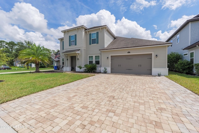 view of front of home featuring a garage, decorative driveway, a front lawn, and roof with shingles