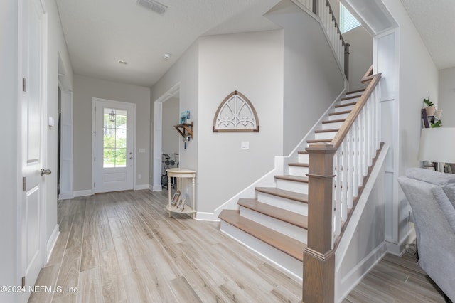 entrance foyer featuring a textured ceiling and light hardwood / wood-style floors