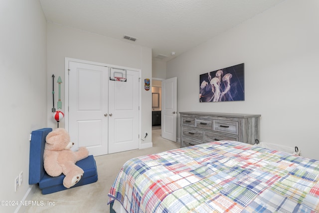 bedroom featuring light carpet, a closet, and a textured ceiling