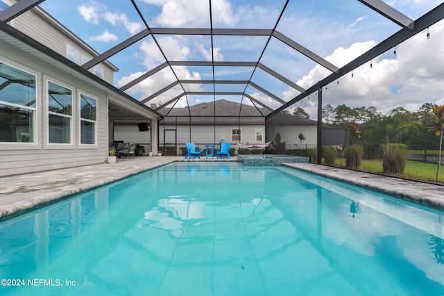 view of swimming pool featuring a patio and a lanai