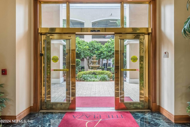 entryway featuring marble finish floor and baseboards