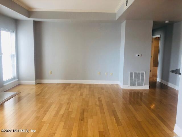 unfurnished room with baseboards, visible vents, and light wood finished floors