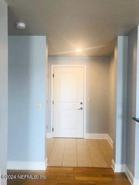 hallway featuring baseboards and wood finished floors