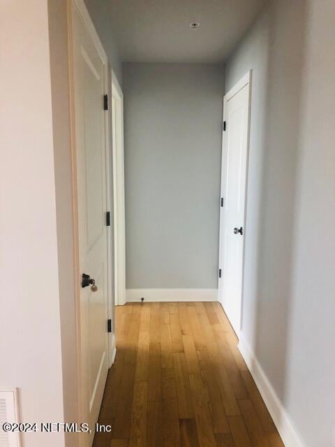 hallway with baseboards and wood finished floors