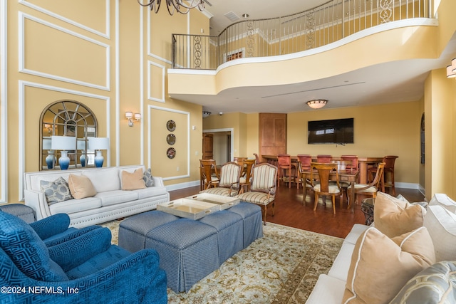 living room featuring a high ceiling, baseboards, and wood finished floors