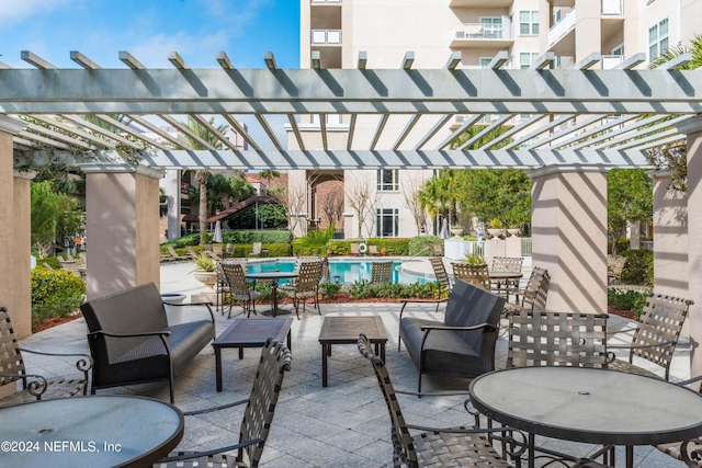view of patio with outdoor dining space, a pergola, and a community pool