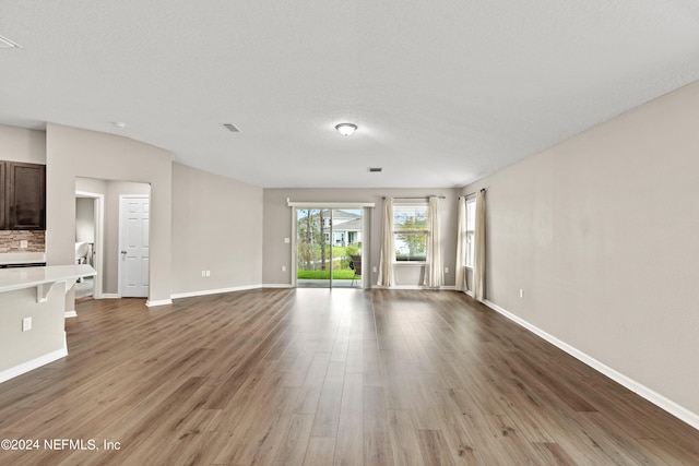 unfurnished living room featuring a textured ceiling and hardwood / wood-style flooring