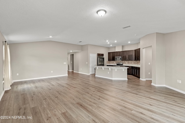 unfurnished living room with a textured ceiling, lofted ceiling, and light hardwood / wood-style flooring