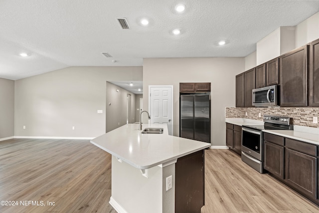 kitchen featuring lofted ceiling, sink, tasteful backsplash, a kitchen island with sink, and stainless steel appliances