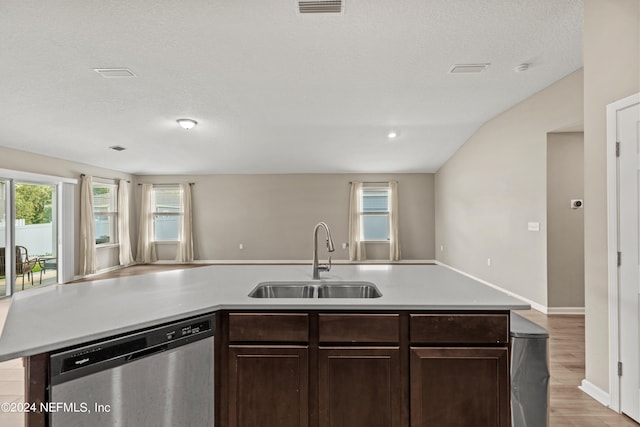 kitchen with sink, stainless steel dishwasher, a textured ceiling, a center island with sink, and light wood-type flooring