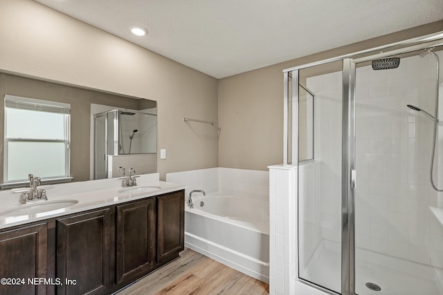 bathroom with hardwood / wood-style floors, independent shower and bath, and vanity