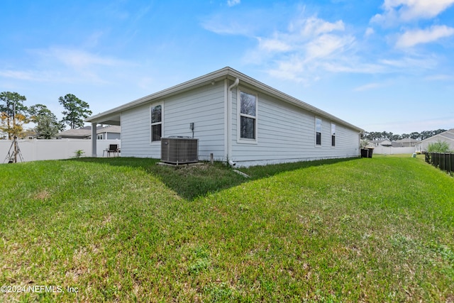 back of house with a lawn and central AC unit