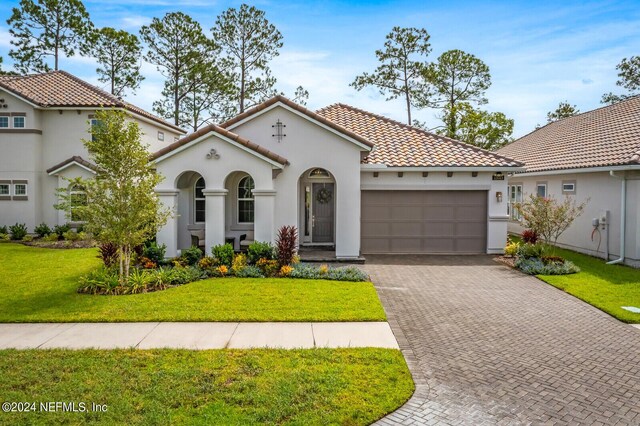 mediterranean / spanish-style home with a garage and a front yard