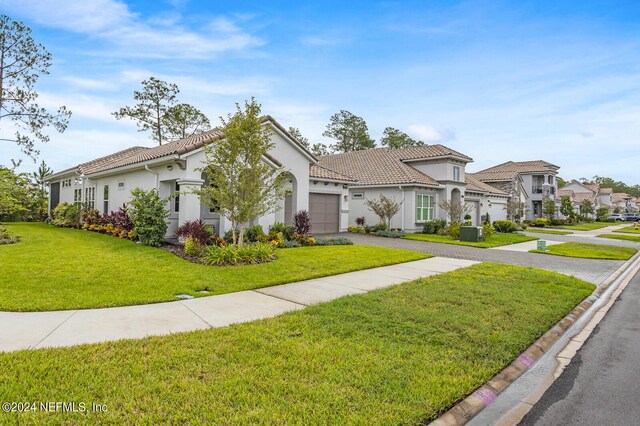 mediterranean / spanish house with a front yard and a garage